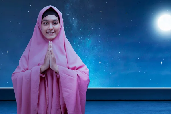 アジア系ムスリム女性でベールの中で挨拶ジェスチャーで夜のシーンの背景 — ストック写真
