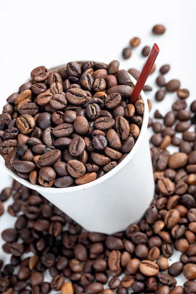白いプラスチック製のカップと白い背景のコーヒー豆の近くのビュー — ストック写真