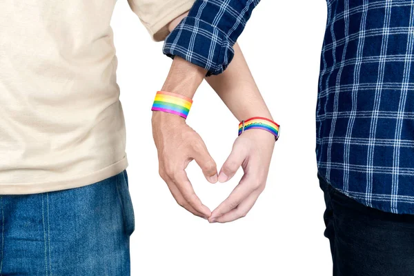 白い背景にハートの形をしたLgbtの虹色のリストバンドを持つゲイのカップル — ストック写真