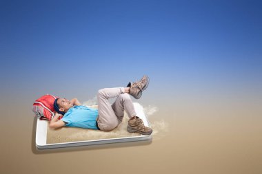 Kumlu cep telefonu ekranı. Cep telefonu ekranında kumlu sahilde sırt çantasında oturan bereli Asyalı adam. Seyahat kavramı
