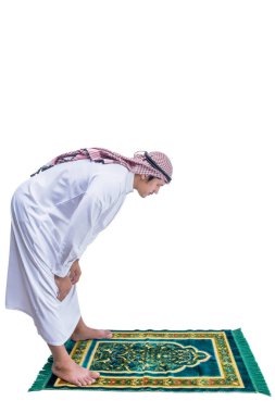 Keffiyeh 'li Müslüman bir adam beyaz arka planda izole edilmiş bir halı üzerinde namaz kılıyor.