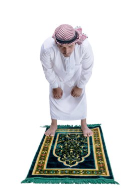 Keffiyeh 'li Müslüman bir adam beyaz arka planda izole edilmiş bir halı üzerinde namaz kılıyor.