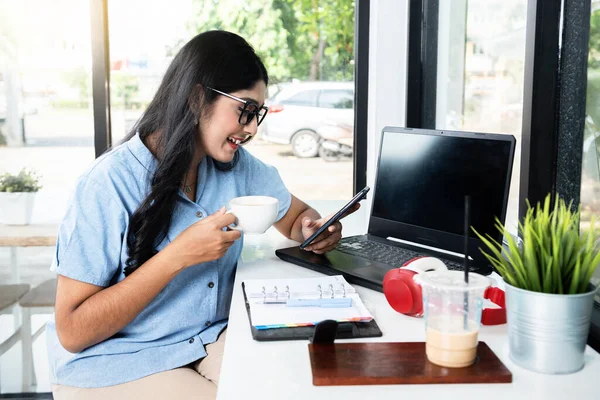 Asian Woman Eyeglasses Laptop Notebook Table Holding Cup Coffee While —  Fotos de Stock