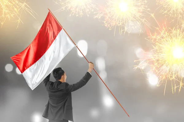 Οπίσθια Όψη Ασιάτη Επιχειρηματία Που Κρατά Ινδονησιακή Σημαία Φόντο Πυροτεχνήματα — Φωτογραφία Αρχείου