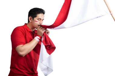 Indonesian men celebrate Indonesian independence day on 17 August by kissing the Indonesian flag isolated over white background