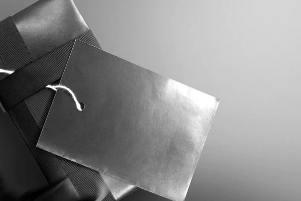 Black gift box with black ribbon and black label tag with a colored background. Black Friday concept
