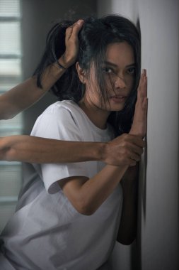 The scared woman is being abused with a man's hand on her hand and her hair. Woman abuse concept