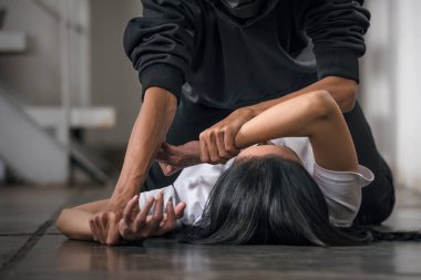 The scared woman is being abused with a man's hand on her hand. Woman abuse concept