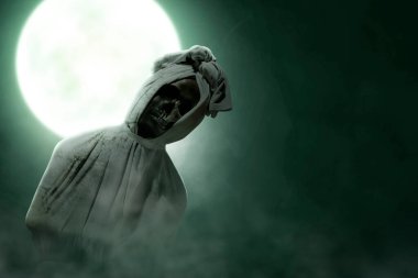 Pocong is covered with a white linen shroud standing with full moon background. Halloween concept