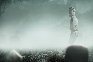 Pocong, mezarlıkta duran beyaz bir keten kefeni ile kaplıdır. Cadılar Bayramı konsepti