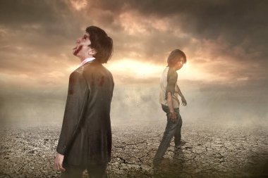 Vücudunda kan ve yara olan korkunç bir zombi sahada yürüyor.