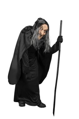 Beyaz arka planda sopayla duran pelerinli yaşlı cadı.