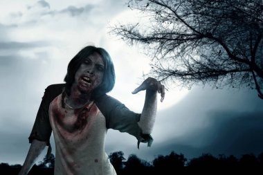 Scary zombie with blood and wound on his body standing with full moon background