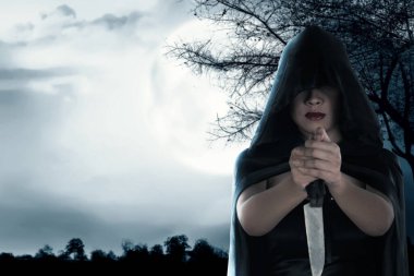 Gece sahne arkasında elinde bıçak tutan Asyalı cadı kadın.