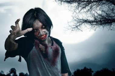 Scary zombie with blood and wound on his body standing with full moon background