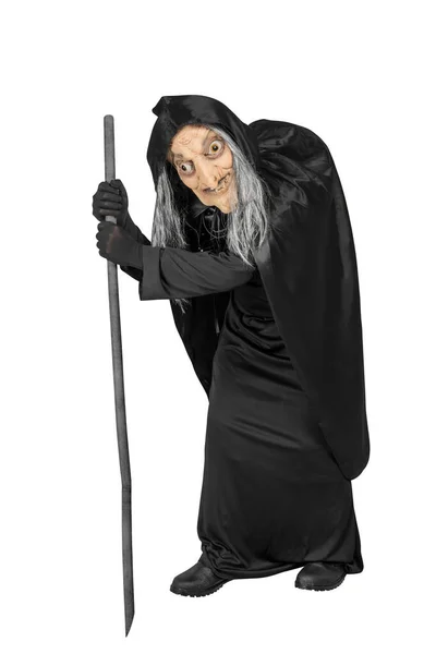 穿着斗篷的老巫婆站在白色背景上 手里拿着一根棍子 — 图库照片
