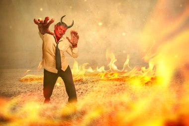 Devilman ateşin arka planında duruyor. Cadılar Bayramı konsepti