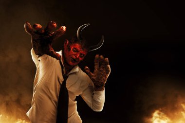 Devilman is standing in the fire's background. Halloween concept