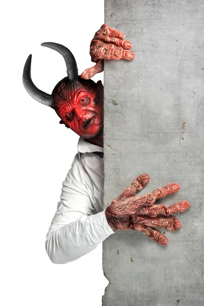 Devilman standing behind the wall isolated over white background. Halloween concept