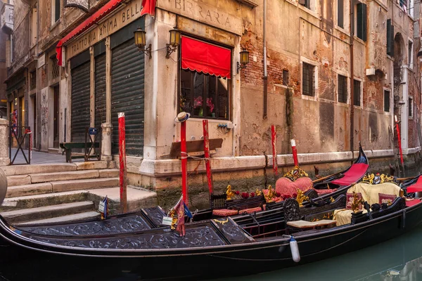 Bela gôndola estacionada ao lado de um pequeno canal em Veneza, Itália Imagem De Stock