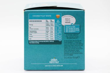 Irvine, İskoçya, İngiltere - 29 Eylül 2021: Bir kutu dolusu Nescafe Dolce-Gusto, geri dönüşümlü ambalajda geri dönüşümlü beyaz hindistan cevizi kahve kapsüllerinde besin bilgileri ve içinde saygı ile büyüyen semboller sergilenmektedir..