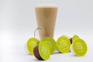 Irvine, İskoçya, İngiltere - 29 Eylül 2021: Uzun bir bardak kahve, Nescafe Dolce-Gusto markalı kapuçino ve süt karışımı geri dönüşümlü kapsüllerde.