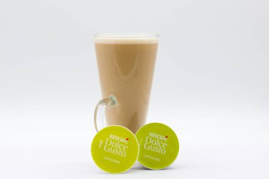Irvine, İskoçya, İngiltere - 29 Eylül 2021: Uzun bir bardak kahve, Nescafe Dolce-Gusto markalı kapuçino ve süt karışımı geri dönüşümlü kapsüllerde.