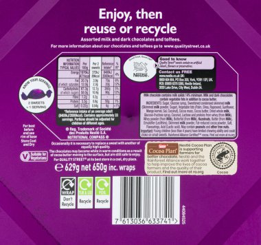 Irvine, İskoçya, İngiltere - 29 Eylül 2021: Bir kutu Nestle markalı Kaliteli Sokak Şekerleme markalı çikolataların arkasında plastik geri dönüşümlü kutular ve etiketler ve besin ve geri dönüşüm bilgileri gösteriliyor.