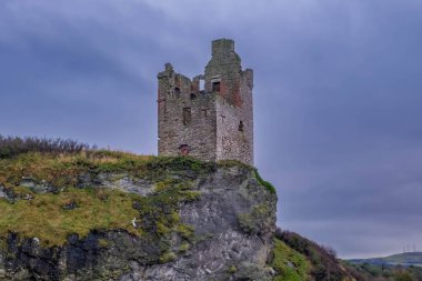 Ancient Ruins of what is left of Greenan Castle perched precariously close to the edge of the cliff face in Ayr Scotland with the stonework almost bleached with the harsh scottish winds. clipart