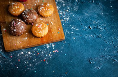 Lezzetli çikolatalı ve vanilyalı kekler. Beton desenli masa, üst manzara. Pudra şekerli tatlı hamur işleri 