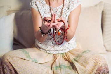 Sakin bir kadın meditasyon yapıyor. Kız etnik giysiler giyiyor. Doğal malzemeler. Zen gebeliği. Sağlık zihinsel konsepti
