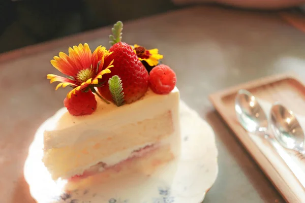 カフェの葉と花で装飾されたイチゴとラズベリーケーキ — ストック写真