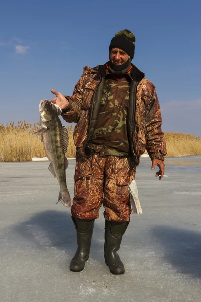 Un homme avec une prise après la pêche sur glace . — Photo