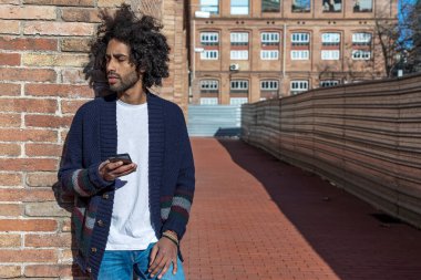 Caddede cep telefonunu kullanan yakışıklı afro adamın portresi..