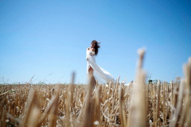 Uzun dalgalı saçlı, beyaz elbiseli, gün batımında buğday tarlasını seven yalnız bir kadın..