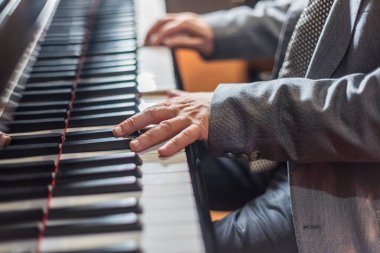 Piyano dersi alırken, erkek ellerinin piyano çalarkenki melodisini yakından izle.