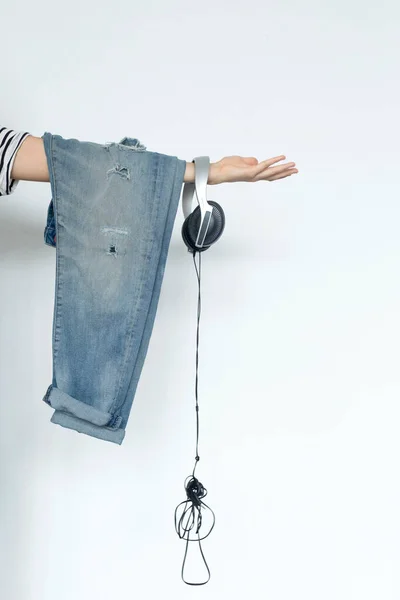 Imagen Recortada Una Mujer Sosteniendo Pantalones Vaqueros Auriculares Sobre Fondo — Foto de Stock