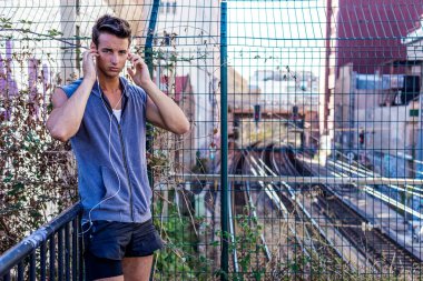 Spor yaptıktan sonra rahatlayan kaslı bir genç adam. Erkek koşucu antrenmana ara veriyor..