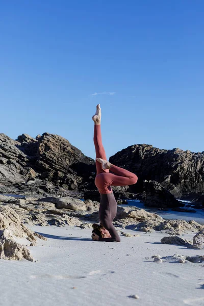 Genç bir kadın yaz yogasında denge kuruyor Formentera, Baleares, İspanya 'da güzel bir plajda.