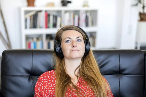 Mujer Rubia Escuchando Música Por Auriculares Mientras Relaja Sofá — Foto de Stock