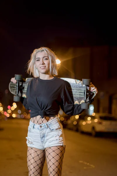 도시에서 스케이트 보드를 거리에 서있는 반바지에 카메라를 여자의 전면보기 — 스톡 사진