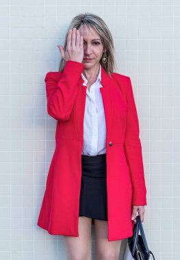 Zarif sarışın kadın kırmızı ceket giyiyor ve yüzü siyah etekli.