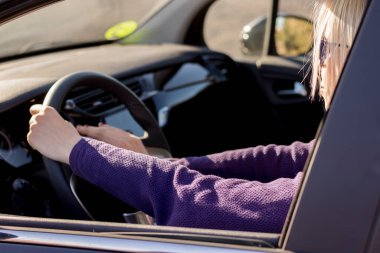 Kadının yakın çekim elleri, direksiyona el sıkışması kornaya basma, yolda, kadın sürücü konsepti