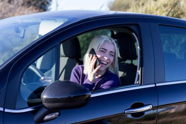 Arabada telefonla konuşan genç kadını sürücüsü