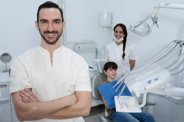 Dentist with his team working in the background