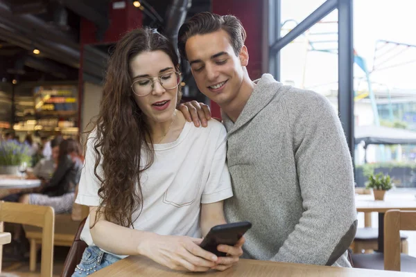 年轻开朗的男人和女人约会和花时间一起在咖啡厅 使用电话 — 图库照片