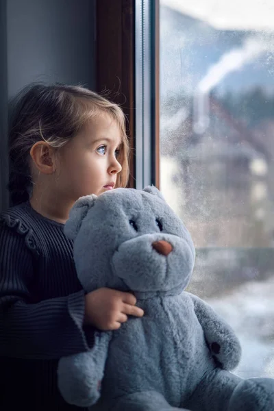 Oyuncak Ayıyla Üzgün Küçük Kız Pencereden Bakıyor Melankolik Ruh Hali — Stok fotoğraf