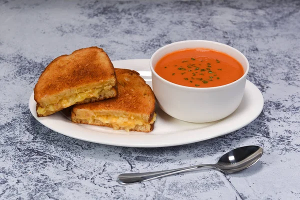 Lezzetli bir domates çorbası ve kızarmış peynirli sandviç..
