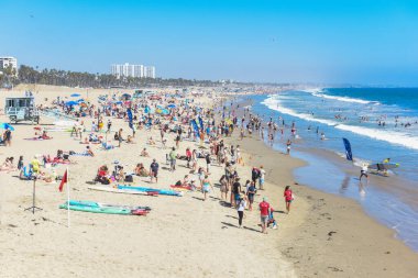 İnsanlar sıcak bir yaz gününde plajda toplanırlar..