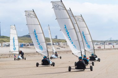 İJMUIDEN, NETHERLANDS - 15 Eylül 2019: Bilinmeyen insanlar rüzgar gücüyle çalışan bir plaj arabasında eğleniyorlar